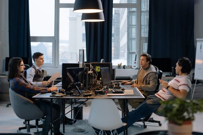 men sitting at table with computers